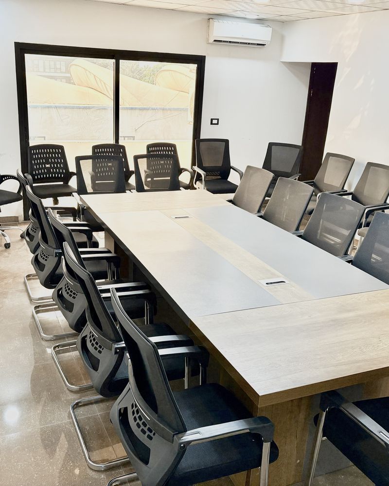 Salle climatisée avec grande table et nombreux fauteuils de réunion